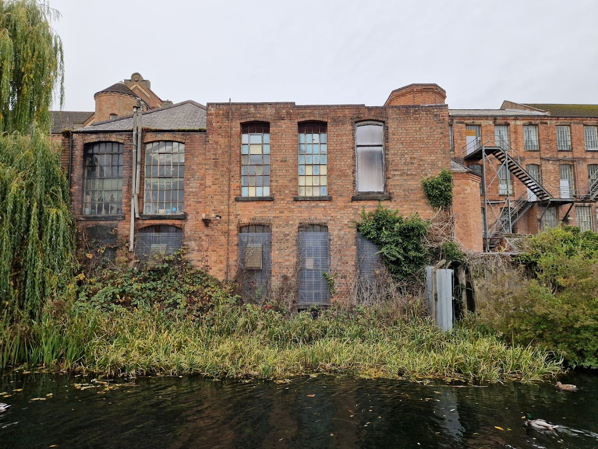 Brick building with large windows along a waterway